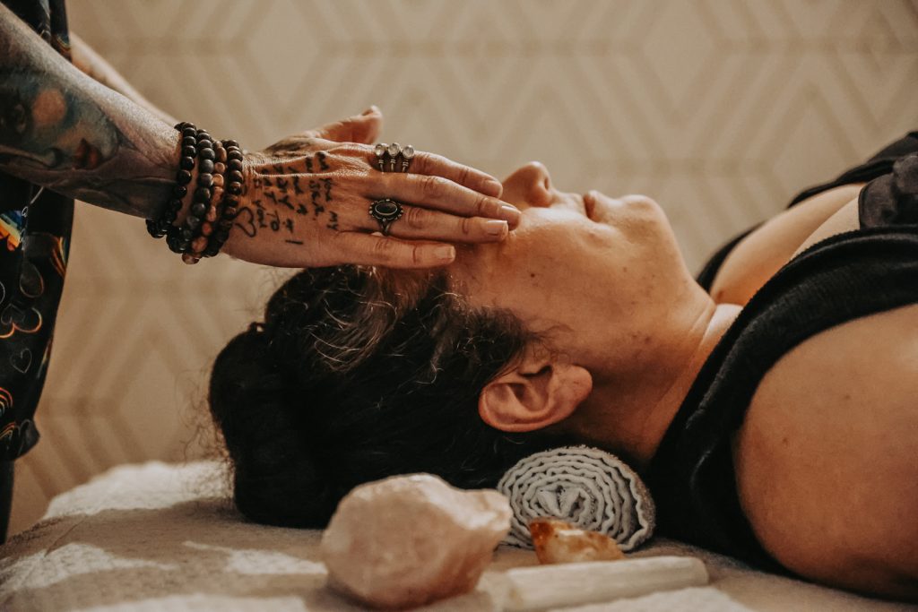 Woman with tattoo hands giving face and head massage