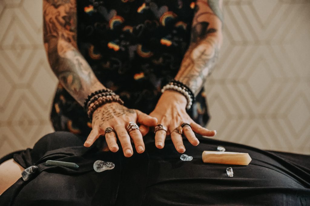 Woman with tattoos giving chakra alignment therapy