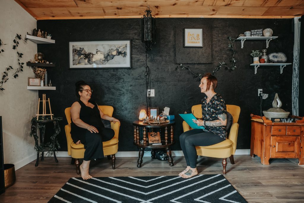 Two smiling women, in waiting area of Misneach Integrative Health Studio